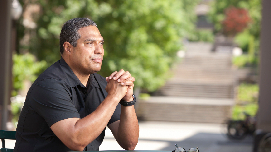 Bonilla-Silva sits outside with glasses on table