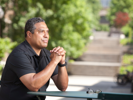 Bonilla-Silva sits outside with glasses on table