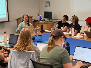 Group of people around conference size table in discussion