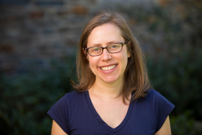 Portrait of professor Jessi Streib with blurred background image of brick wall and greenery